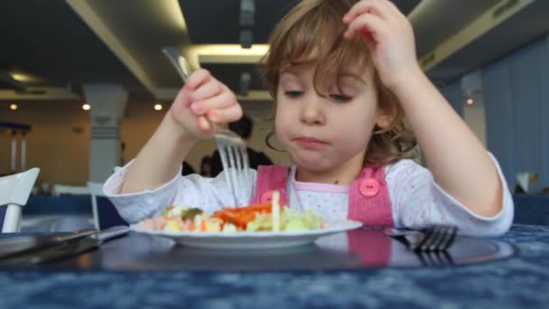 Menina pequena come salada no café — Vídeo de Stock