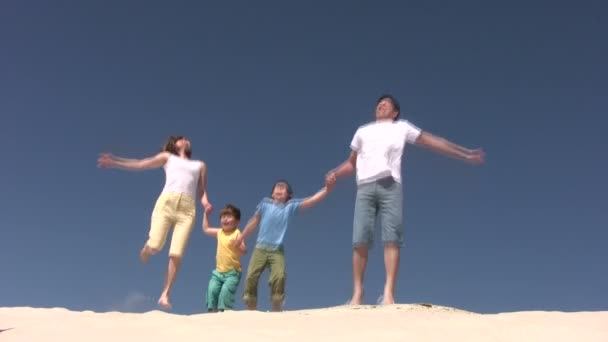 Rodina skáče na písku — Stock video