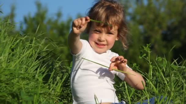 Dziewczyna bawi sie z trawy, co dach — Wideo stockowe