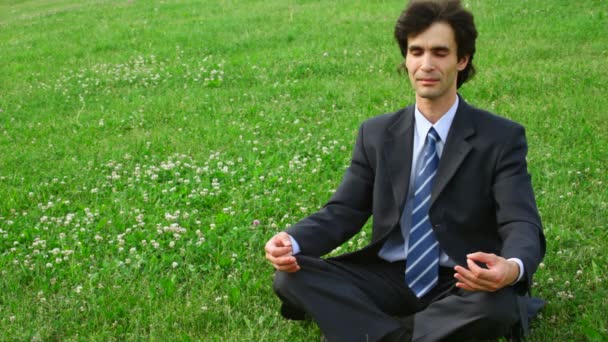 Hombre guapo sentado en pose de loto — Vídeos de Stock