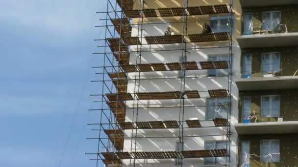 Les constructeurs peignent la maison à plusieurs étages. Délai imparti 