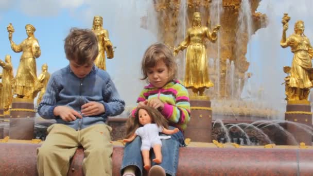 Girl and boy playing, with fountain friendship at All-Russia Exhibition Centre on the background — Stock Video