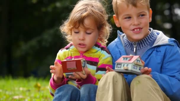 Chłopiec i dziewczynka gra z zabawkami domy, licząc windows — Wideo stockowe