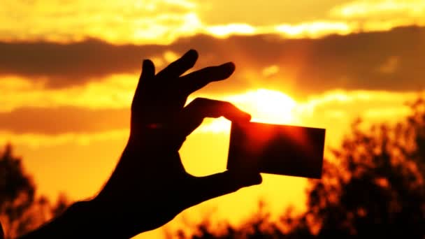 Person hält eine Karte in der Hand gegenüber der Sonne — Stockvideo