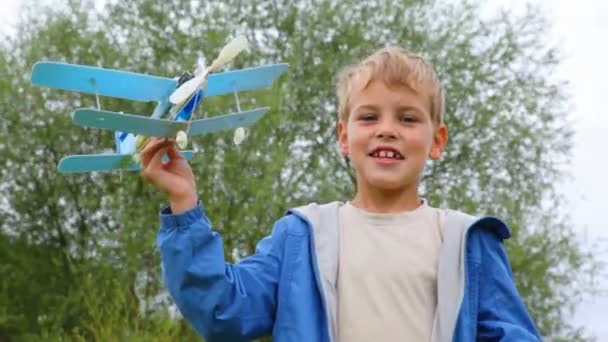 Chico volando aviones de juguete y corriendo detrás de él — Vídeos de Stock