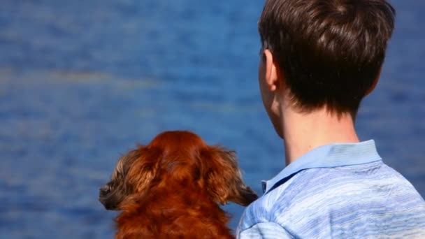 Hombre con perro mira el mar — Vídeos de Stock