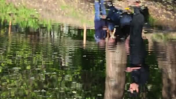 Reflectie van de familie in het water van de rivier — Stockvideo