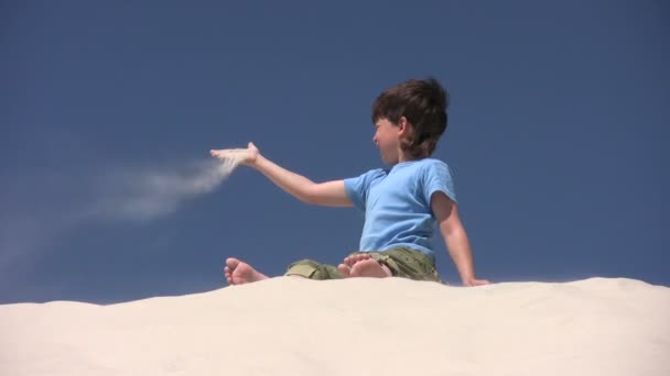 Boy threw the sand on the wind — Stock Video