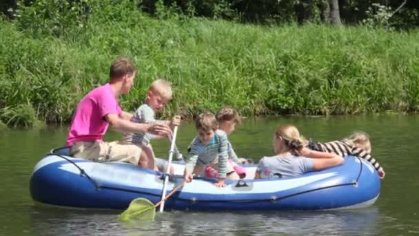 Family with 4 kids in rubber boat, rowing — Stock Video