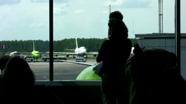 A repülőtéren, az ablak mellett család — Stock videók