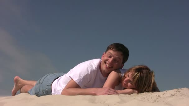 Пара лежащих на песке — стоковое видео