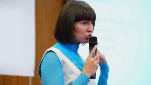 Portrait of woman speaking through a microphone in conference hall — Stock Video