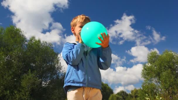 Jongen met blauwe ballon in park — Stockvideo