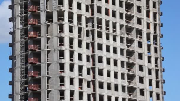 Edificio alto en construcción de abajo hacia arriba con cielo azul — Vídeos de Stock