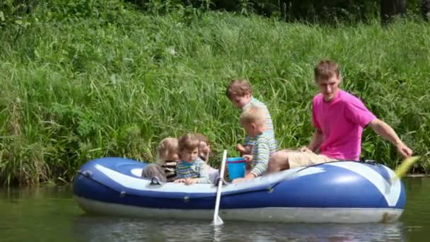 Family with 4 kids in rubber boat, fishing — Stock Video