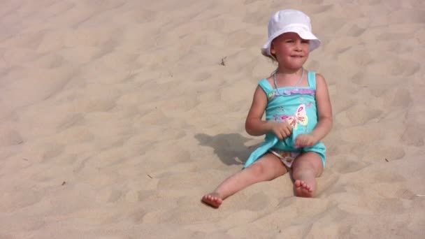 A menina senta-se na areia — Vídeo de Stock