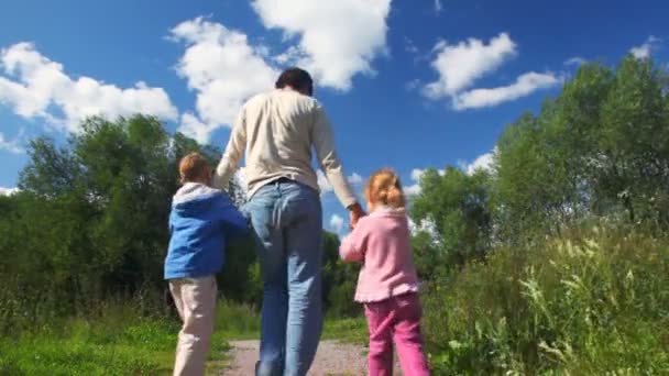 Père tournant avec fille et fils en plein air — Video