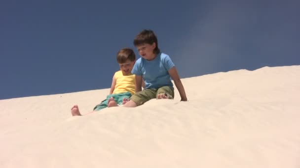 Děti skáčou dolů do písku — Stock video