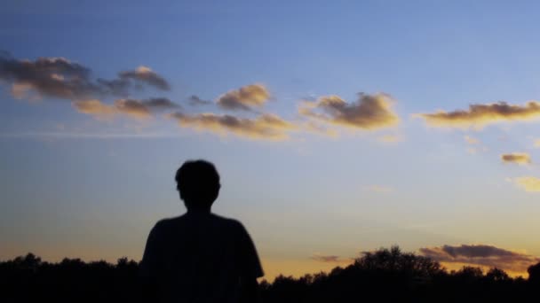 El hombre camina en una puesta de sol — Vídeos de Stock