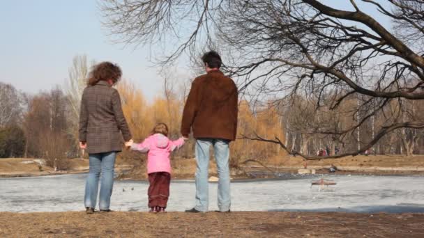 Chica con los padres mira estanque — Vídeo de stock