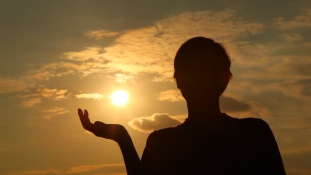 Silhueta de homem em copos que uma palma apoia o sol — Vídeo de Stock