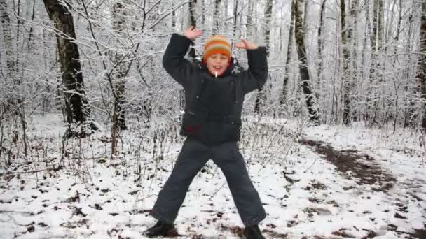Happy boy dances against winter wood, time lapse, boy around camera — Stock Video