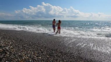 genç bir çift deniz sörf, arka planda bulutlar eğlenir