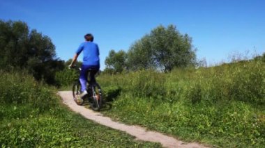 adam da mavi spor kıyafet ve pembe yelek çocuk Bisiklet Park patika üzerinde birbiri ardına devam