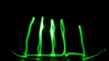 Light graffiti (freezelight): on black background green grass. 