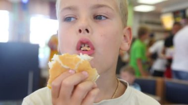 fast food café'de hamburger yiyen çocuk