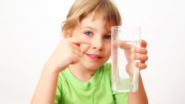 girl shows by little on glass of water 