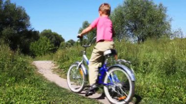 Çocuk pembe yelek ve adam sırayla mavi spor kıyafeti Bisiklet park yolundaki ileriye götürmek için devam