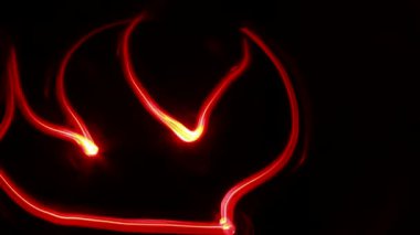Light graffiti (freeze light): on black background red flame. 
