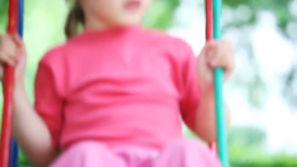 Kis lány szőke pink póló libikóka-park közelében — Stock videók