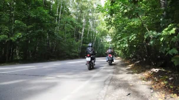 Dva motorkáři na kolech začít na asfaltovou silnici dohromady — Stock video