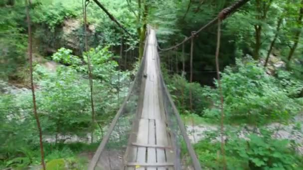 Caméra se déplaçant le long du pont suspendu en forêt — Video