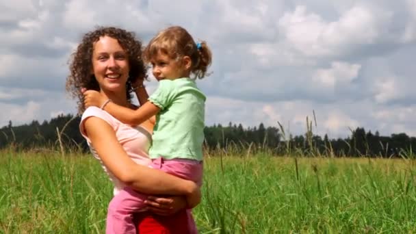 Мать и дочь улыбаются и ходят по полю — стоковое видео