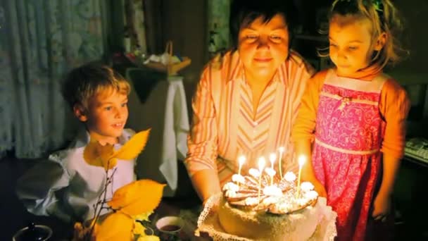 Familia soplando velas en la torta — Vídeos de Stock