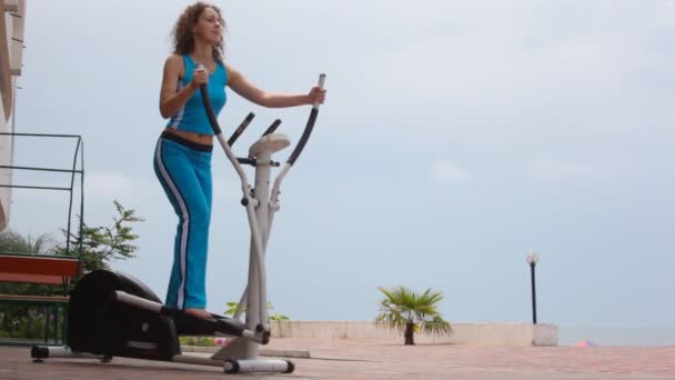 Feliz joven rizada mujer en aparato de entrenamiento al aire libre — Vídeos de Stock