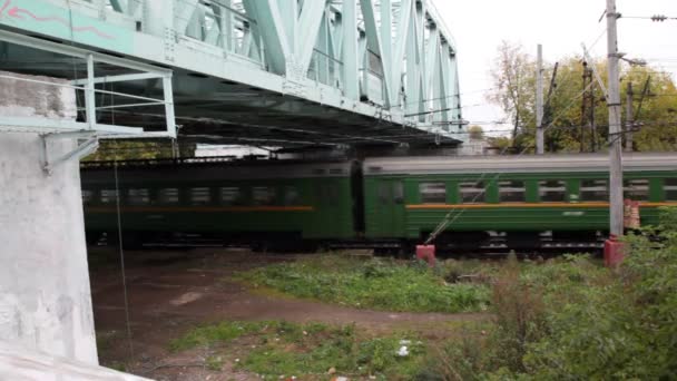 Pociągiem podmiejskim szybko przechodzi pod most żelaza w jesieni — Wideo stockowe