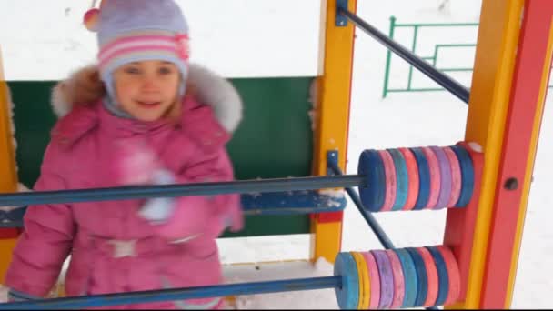 Niña jugando con ábaco en el patio de invierno de la ciudad — Vídeo de stock