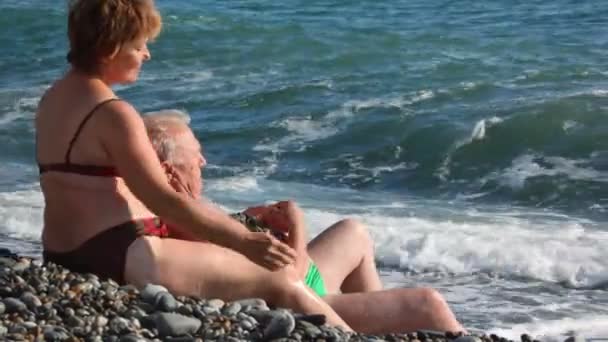 Adult, aged, beach, couple, elderly, female, happy, love, man, nature, ocean, outdoor, pair, pebble, recreation, sea, senior, sit, summer, sunlight, sunny, surf, water, wave, woman — Stock Video