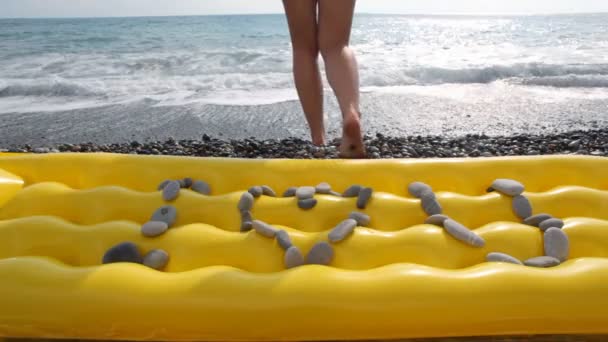 Ich liebe dich Inschrift aus Steinen am Strand, Frau im Meer im Hintergrund — Stockvideo