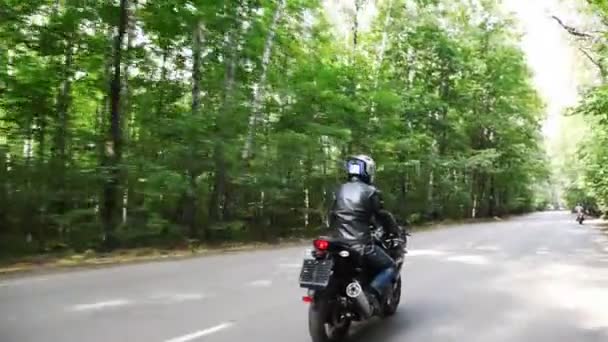 Biker catches up with other biker on road. Moving camera — Stock Video