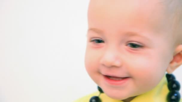 Portrait of smiling little girl with beads against white background — Stock Video