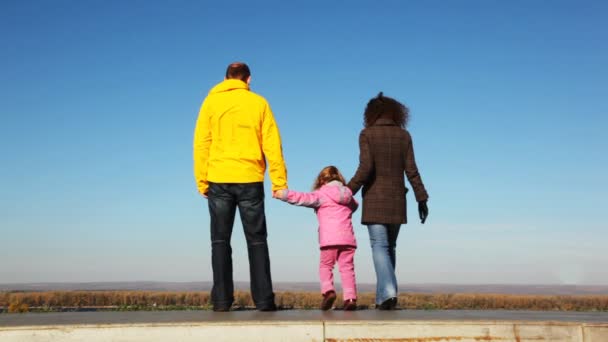 Mans ffamily de mamá, los papás y la hija va hacia arriba desde la plataforma antes de la encuesta tipo de madera y skyace en chaqueta amarilla de cerca en el parque en otoño — Vídeos de Stock
