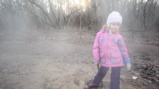 Little girl with stick standing near steaming sewer manhole — Stock Video