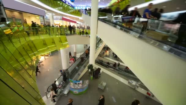 Clientes que se mueven en escaleras mecánicas en la tienda del centro comercial grande, gran angular — Vídeo de stock