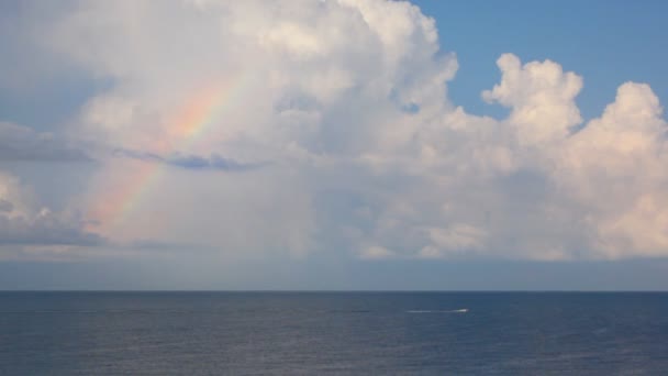 Utter se movendo no mar sob o céu com nuvens e arco-íris — Vídeo de Stock