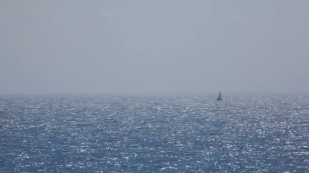 Kleine zeilboot verplaatsen in zee met glanzende reflecties — Stockvideo